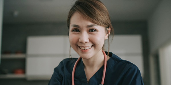 A female clinician is writing on book with a pen.