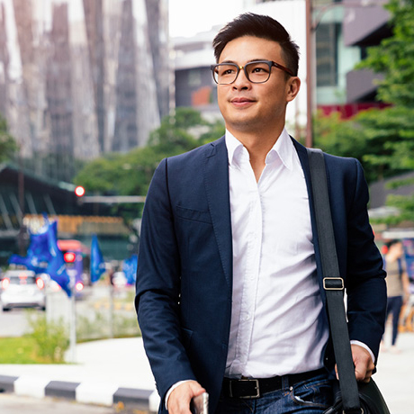 Man wearing suit walking outdoor.