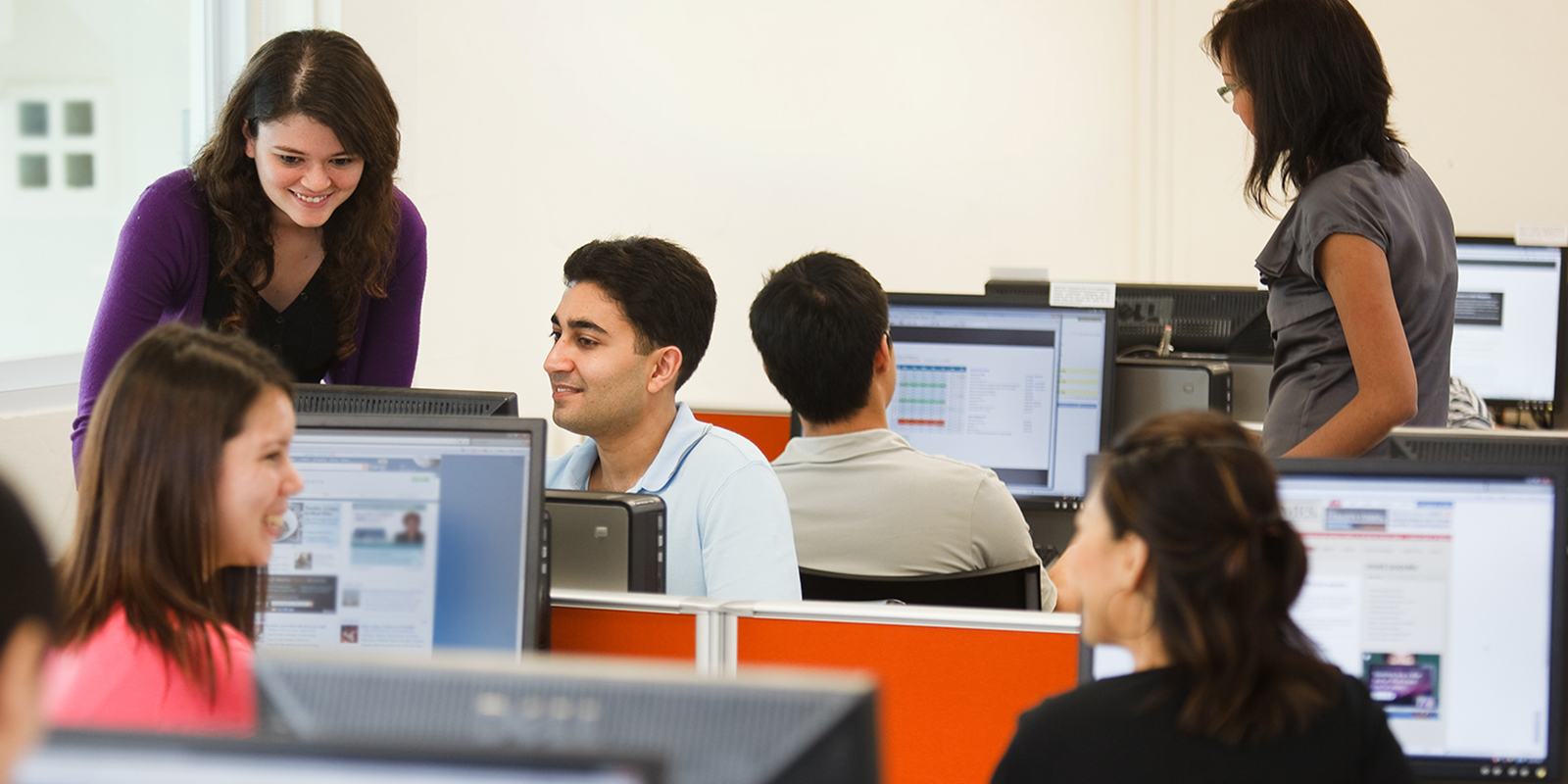 Students are working on desktop computer in computer laboratory.