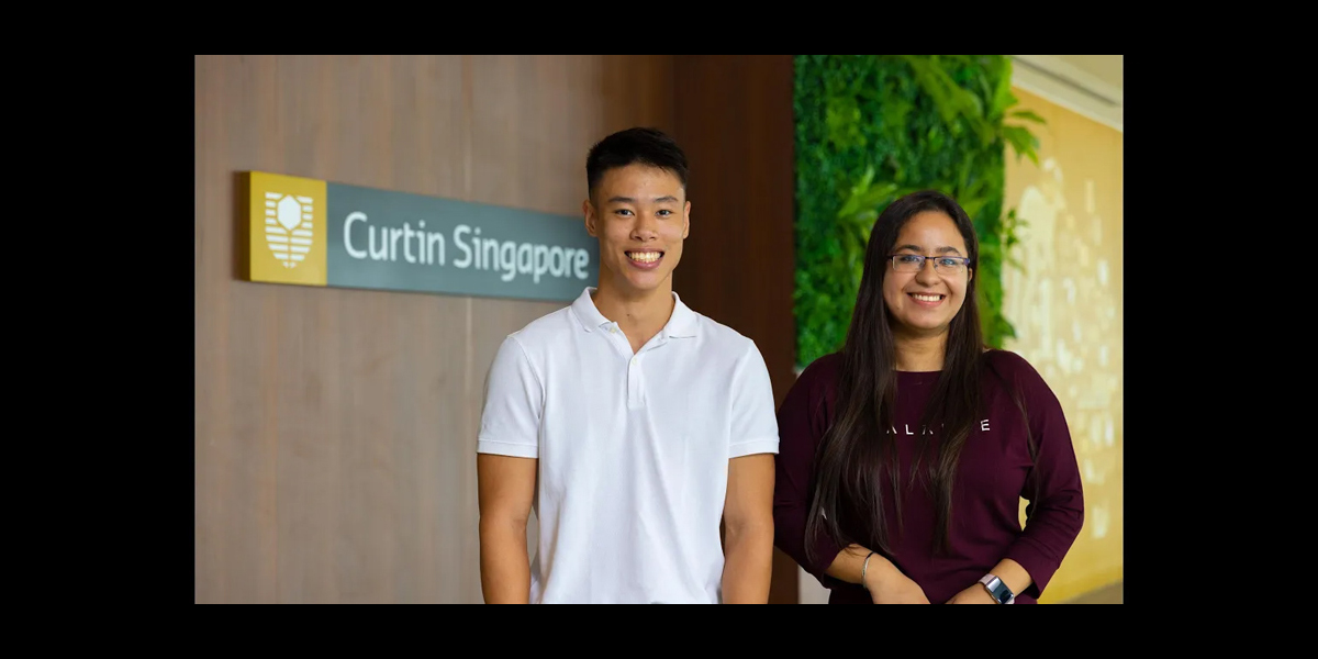 Male and Female studetns posing in curtin singapore corridor. - play video