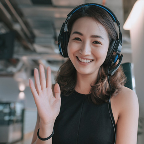Woman wearing headphone and wave hand.